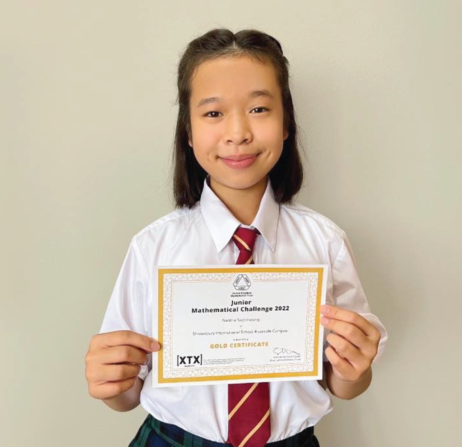 Annie holding her UKMT Junior Mathematical Challenge 2022 Gold Certificate