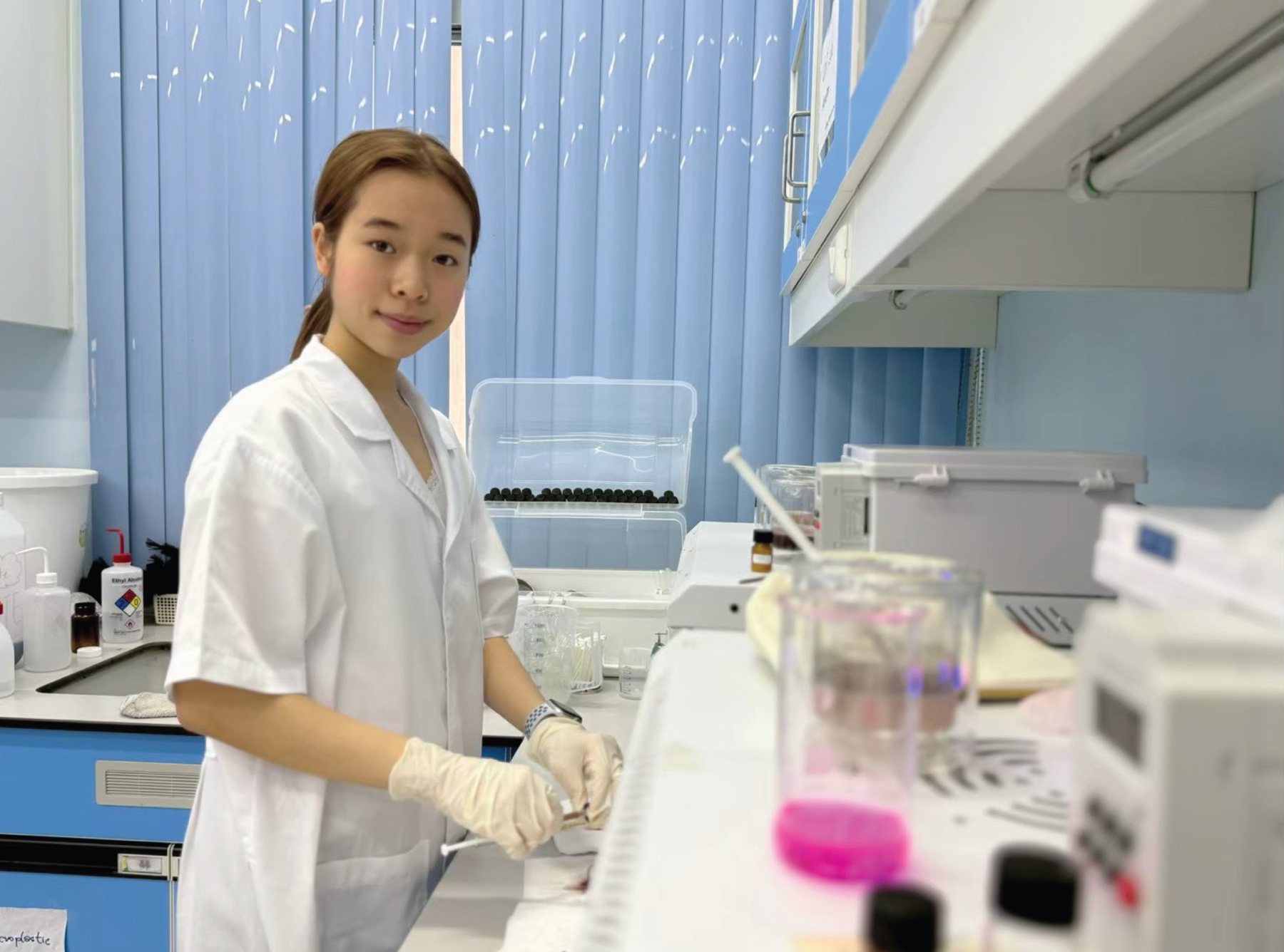 Annie working at a laboratory bench with a sample flask