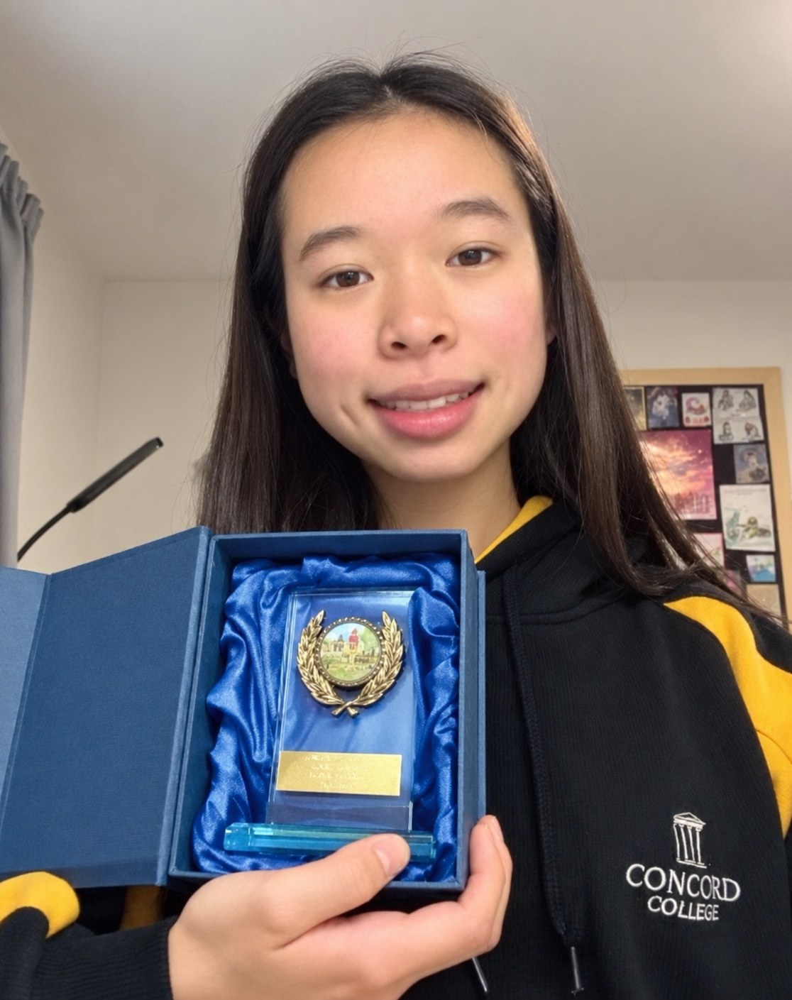 Annie holding her cross-country trophy
