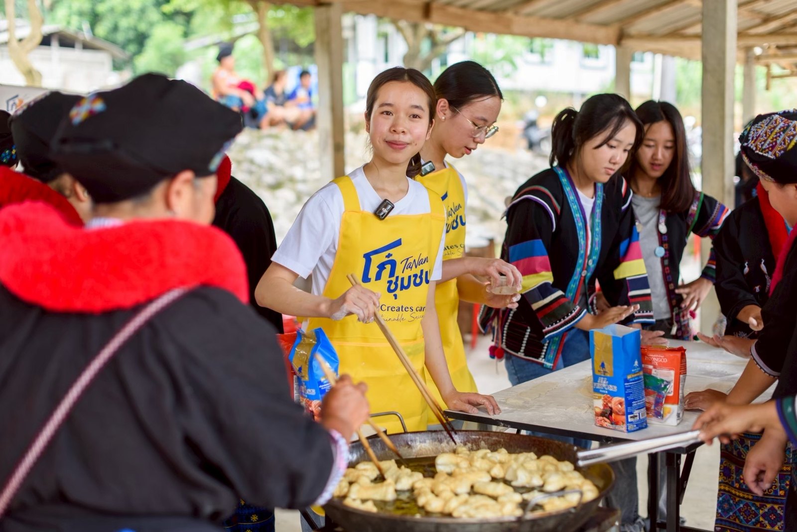 Annie frying patongko with villagers at the Village Hall in Mae Chan, Chiang Rai