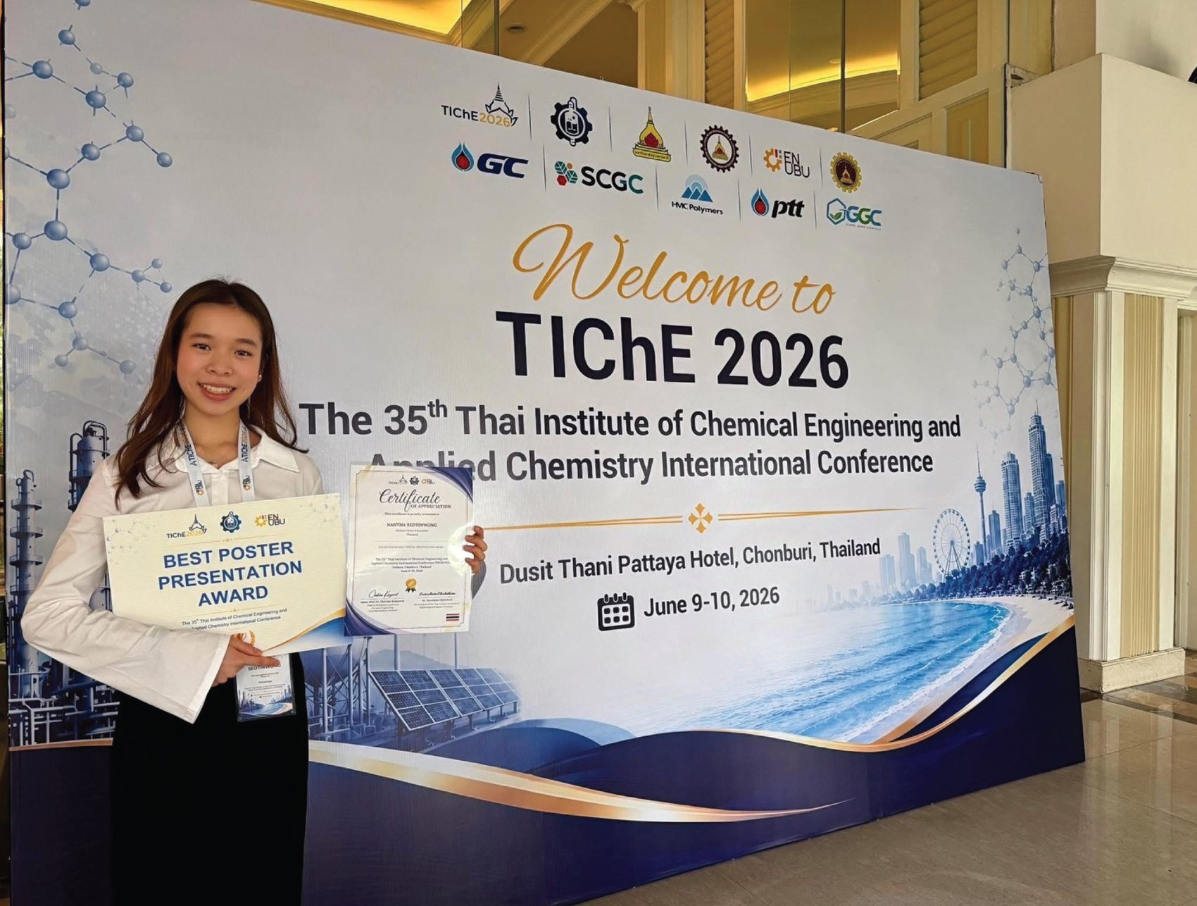 Annie holding her award and certificate in front of the TIChE 2026 banner
