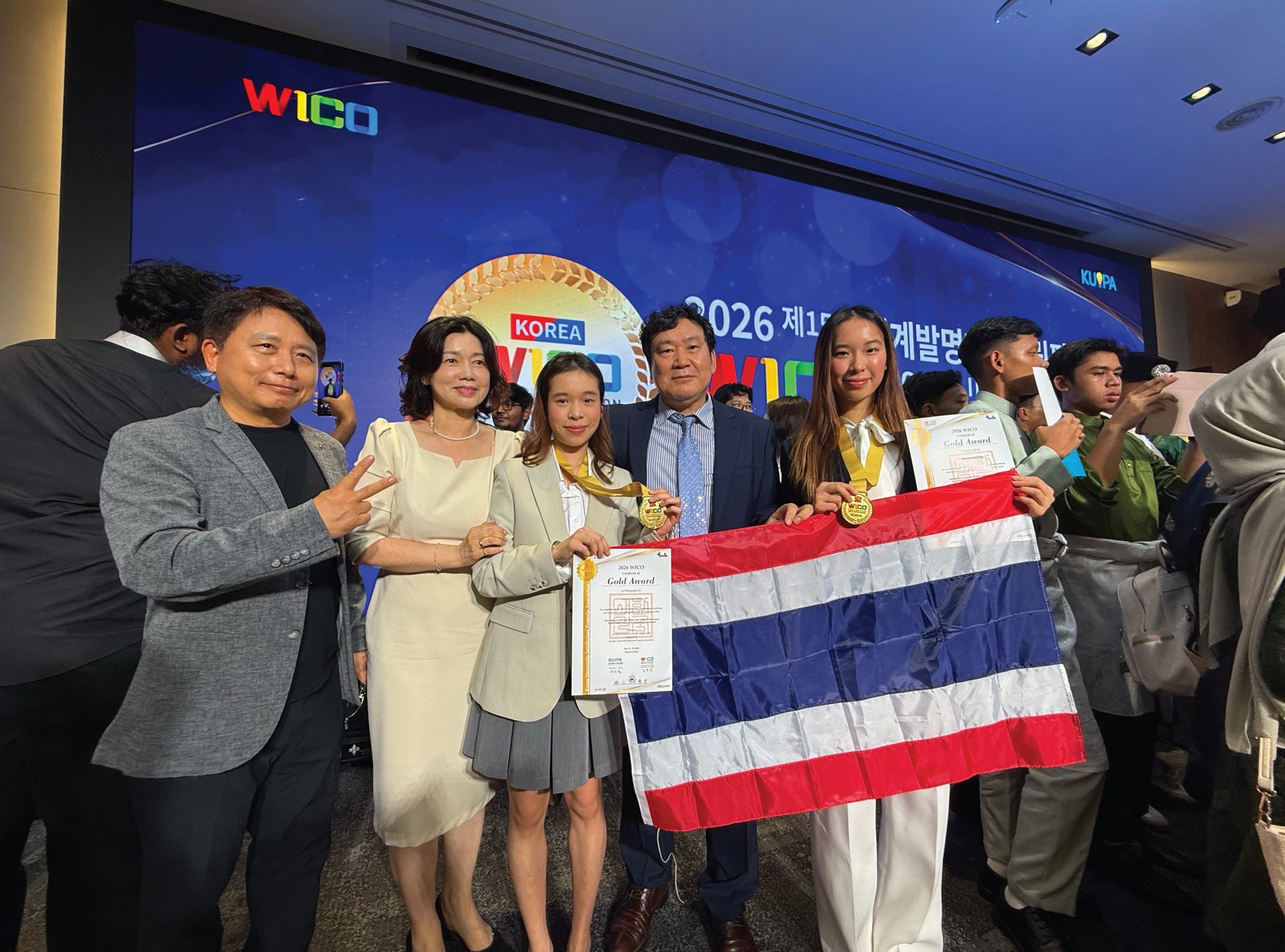 Annie with the Thai delegation holding the Thai flag at WICO 2026