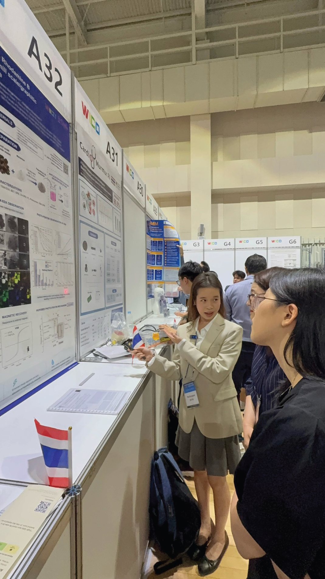 Annie presenting her research poster to a visitor at WICO 2026